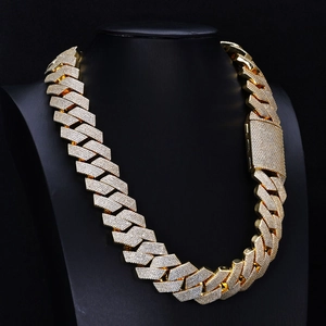 Macro shot of gold-plated iced-out Cuban chain necklace with diamond accents on a bust
