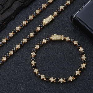 Dettaglio di bracciale tennis e collana placcati in oro con zirconi neri e maglie a stella