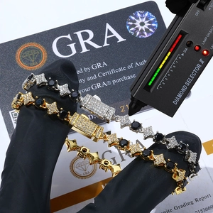 Nahaufnahme von silbernen und goldenen Stern-Tennisarmbändern mit schwarzem Moissanit