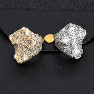 Vista macro di anelli hip hop oro e argento con design a croce e pietre di zircone