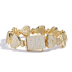 Bracelet hip hop doré avec maillons cœur, signes dollar et pierres CZ sur fond blanc