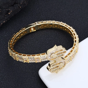 Macro shot of gold Hamsa hand bracelet with cubic zirconia paving and spring clasp mechanism