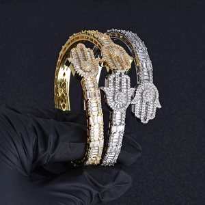 Macro shot of gold and silver Hamsa Hand bracelets encrusted with sparkling zircons