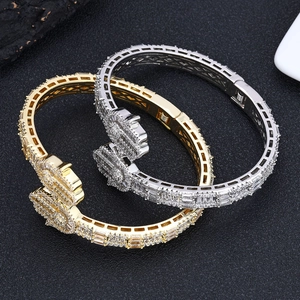 Iced out gold and silver crossover bangles with pavé set cubic zirconia stones