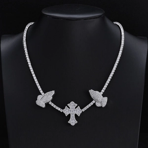 Detail of hip hop silver tennis chain with cross pendant and praying hands motifs