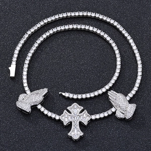 Close-up of S925 silver moissanite tennis chain with cross and praying hand pendants