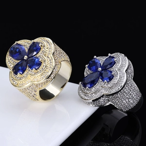 Macro view of blue pear-cut sapphire clover rings with micro-pave cubic zirconia setting