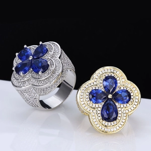 Macro shot of luxurious hip hop rings with blue flower zircon and full diamond pave band