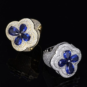 Macro shot of hip-hop rings with blue clover gemstones and micro-paved cubic zirconia