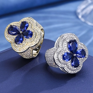 Macro shot of hip hop style clover rings with blue stones and full pave diamonds