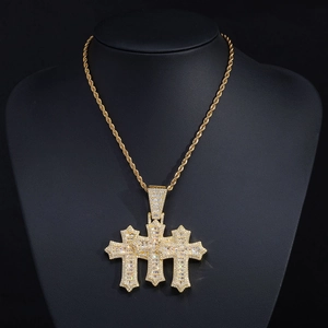 Macro view of iced out triple layer cross pendant with baguette and round cut zircons
