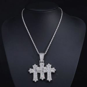 Macro shot of silver hip hop triple cross pendant encrusted with glittering zircons