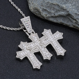 Macro detail of triple cross pendant with cubic zirconia on a rope chain necklace