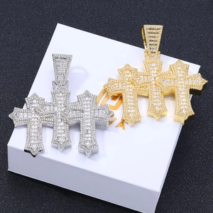 Macro view of iced out hip hop cross pendant with gold and silver zircon settings