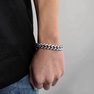 Close-up of a silver-colored iced-out 12mm Cuban link bracelet with pavé-set zircons