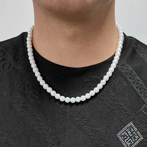 Élégant collier de perles blanches de 8 mm porté par un mannequin sur fond noir