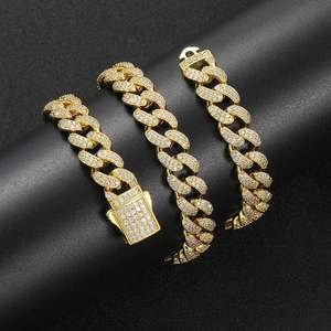 Macro detail of 12mm golden Cuban link chain with double row zircon and secure spring clasp