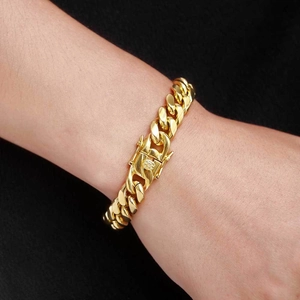 Gros plan d'un bracelet gourmette doré au poignet avec fermoir à tête de dragon
