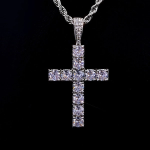 Dettaglio di un ciondolo a croce in argento con zirconi lucidi e catena a corda