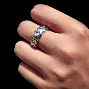 Dettaglio dell'anello a catena cubana da 8 mm in argento lucido indossato su sfondo nero