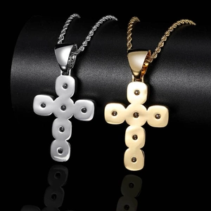 Détail de pendentifs croix bulles or et argent avec chaînes torsadées sur fond noir