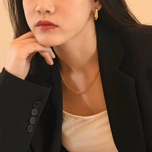 Gros plan d'une chaîne corde plaquée or 18 carats et de créoles rectangulaires