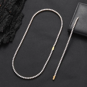 Dettaglio del set collana e bracciale tennis dorati con zirconi su trama nera