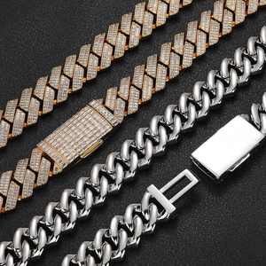 Detail view of gold iced-out and silver polished 20mm cuban link chains with box clasps