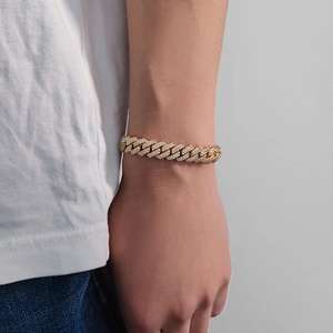 Gros plan d'un bracelet Cuban link de 10mm doré avec zircons porté sur le poignet