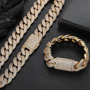 Close-up of gold 20mm iced out Cuban link necklace and bracelet set with cubic zirconia