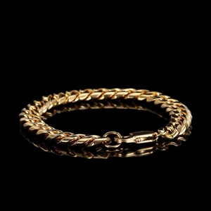 Détail du bracelet gourmette doré avec fermoir à ressort circulaire poli sur noir