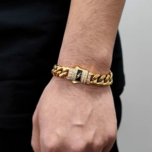 Detail of gold Cuban bracelet with lightning bolt buckle and rectangular cubic zirconia stones