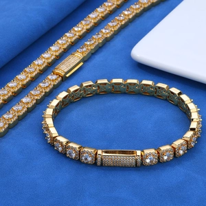 Nahaufnahme von goldenem Hip-Hop-Schmuckset mit Zirkonia-Steinen und verzierten Gliedern