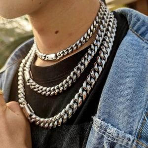 Close-up of triple layered silver stainless steel Cuban link chains on male model