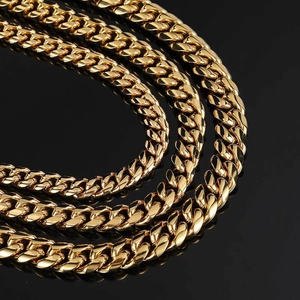 Close-up of triple-layered high-polish golden Cuban link chains with heavy metal texture