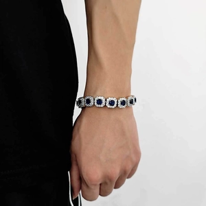 Macro shot of a hip hop silver bracelet with six large blue gems and white iced out crystals