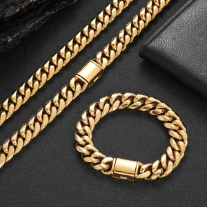 Polished gold curb chain necklace and bracelet set for men on a dark textured background