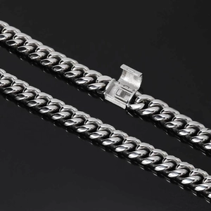 Macro shot of silver-toned stainless steel Cuban link chain with detailed box clasp