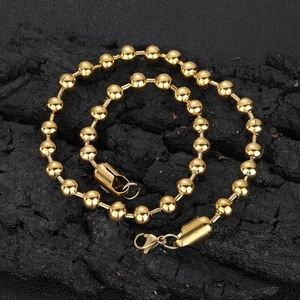 Polished 8mm gold stainless steel bead chain necklace with lobster clasp on dark stone