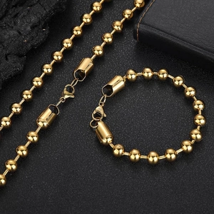 Close-up of golden stainless steel ball chain set with lobster clasp on black background