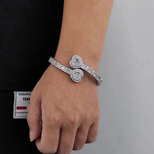 Detailed view of silver open cuff bracelet with dual heart-shaped pavé zircon accents