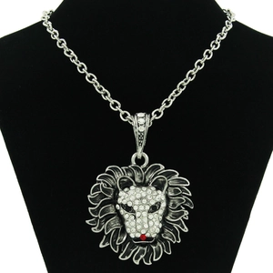 Detailed close-up of a silver lion head pendant necklace encrusted with white and red crystals