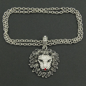 Detailed macro view of lion head pendant with sparkling rhinestones and red gem nose