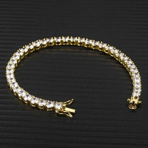 Vista macro di un bracciale tennis dorato con zirconi tondi e chiusura di sicurezza