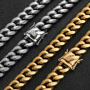 Polierte Edelstahl-Cuban-Halsketten in Silber und Gold auf schwarzem Lederhintergrund