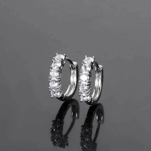 Macro shot of silver-plated hoop earrings featuring five round-cut cubic zirconia stones