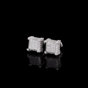 Macro detail of silver square micro-paved zircon stud earrings with reflective black background