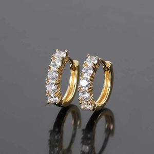 Macro shot of gold-plated hip hop huggie earrings with five round-cut zircons