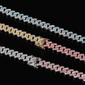 Détail macro des chaînes Cuban Link 9mm avec zircons colorés et fermoirs pavés étincelants