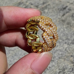 Dettaglio dell'anello a catena cubana dorato con pavé di zirconi luccicanti